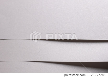 White pearl paper background with a glossy satin texture and layered folded strips. Icy silver and White pearl paper background with a glossy satin texture and layered folded strips. Icy silver and 125557783