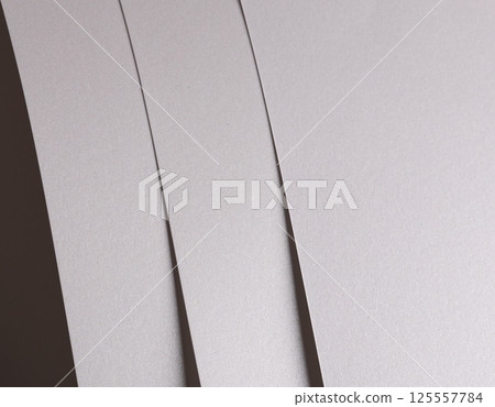 White pearl paper background with a glossy satin texture and layered strips in a flowing, balanced 125557784