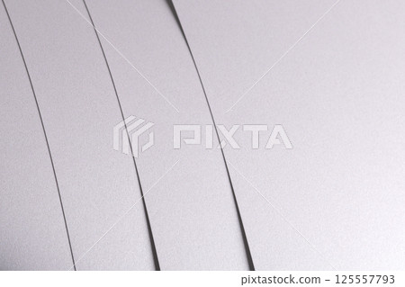 White satin paper background with a glossy, smooth texture and layered strips. Pale grey and icy 125557793