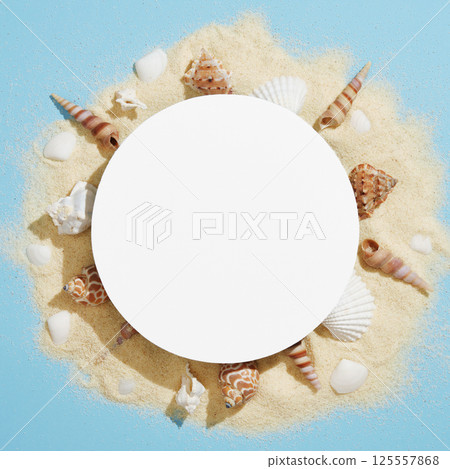 Round frame made of white sand and various white and brown shells on a light blue background. A space for your text. Round frame made of white sand and various white and brown shells on a light blue background. A space for your text. 125557868