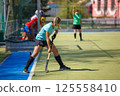 Young Female Player Performing Corner Strike in Field Hockey Game 125558410