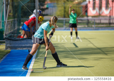 Young Female Player Performing Corner Strike in Field Hockey Game Young Female Player Performing Corner Strike in Field Hockey Game 125558410