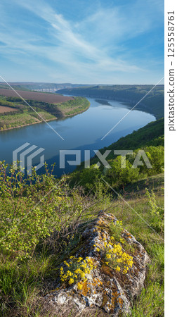 Amazing spring view on the Dnister River Canyon with picturesque rocks, fields, flowers. This place named Shyshkovi Gorby, Nahoriany, Chernivtsi region, Ukraine. Amazing spring view on the Dnister River Canyon with picturesque rocks, fields, flowers. This place named Shyshkovi Gorby, Nahoriany, Chernivtsi region, Ukraine. 125558761