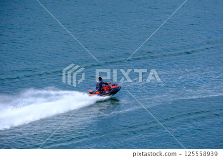 People enjoying jet skiing on a holiday under the blue sky in early summer at Ashiyahama Beach in Ashiya City, Hyogo Prefecture 125558939