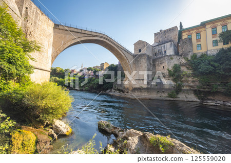 The Stari Most bridge, old bridge on Neretva river in Mostar town, Bosnia and Herzegovina, Europe. Stone bridge with an arch over a flowing river. The Stari Most bridge, old bridge on Neretva river in Mostar town, Bosnia and Herzegovina, Europe. Stone bridge with an arch over a flowing river. 125559020
