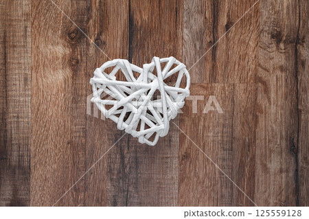 Wicker Heart Decor on Rustic Wooden Floor Symbolizing Love and Warmth 125559128