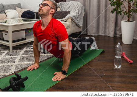 Man practicing yoga in a modern living room Man practicing yoga in a modern living room 125559671