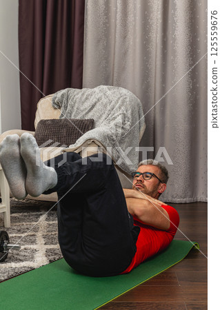 Man working out at home during the afternoon Man working out at home during the afternoon 125559676