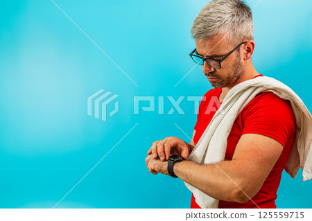 Man checks smartwatch while wearing workout gear 125559715