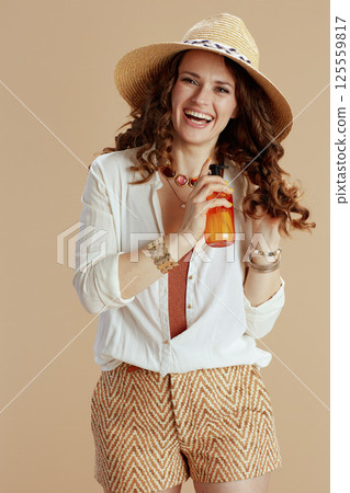 smiling stylish female in blouse and shorts isolated on beige smiling stylish female in blouse and shorts isolated on beige 125559817
