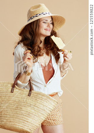 smiling woman in blouse and shorts against beige 125559822