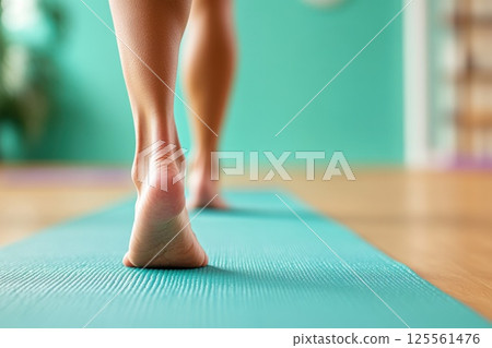Walking barefoot on a yoga mat in a serene meditation studio with calming colors 125561476