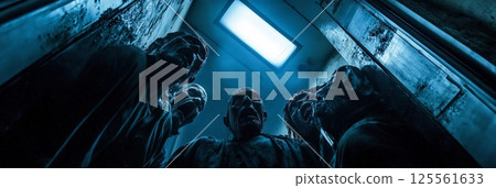 Four scary undead creatures are screaming while trapped together inside a dirty and rusty elevator with a light illuminating them from above, creating a dramatic and eerie atmosphere Four scary undead creatures are screaming while trapped together inside a dirty and rusty elevator with a light illuminating them from above, creating a dramatic and eerie atmosphere 125561633