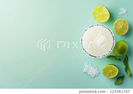 Minimalist cocktail setup featuring margarita glass and fresh lime on pastel blue background Minimalist cocktail setup featuring margarita glass and fresh lime on pastel blue background 125561787