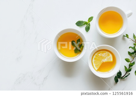 Refreshing iced green tea with mint and lemon displayed on a marble tabletop 125561916