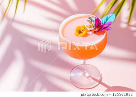 Vibrant pink cocktail with flower petals and sugar rim in bright sunlight Vibrant pink cocktail with flower petals and sugar rim in bright sunlight 125561953