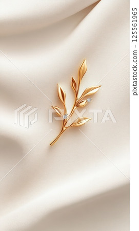 Gold pendant designed as a delicate branch with diamond accents on a light background Gold pendant designed as a delicate branch with diamond accents on a light background 125561965