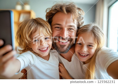 Father enjoys a playful selfie moment with his joyful children in a bright home setting 125562231