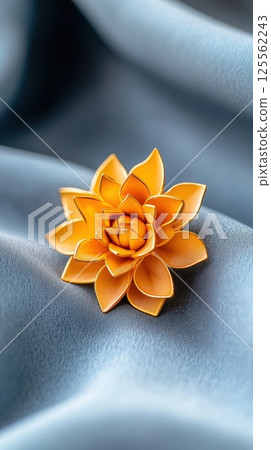 Stylized gold flower brooch with matte and glossy textures on elegant velvet background Stylized gold flower brooch with matte and glossy textures on elegant velvet background 125562243
