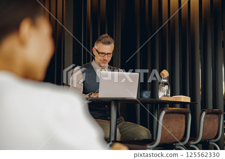 Focused Professional Working in Modern Caf Focused Professional Working in Modern Caf 125562330