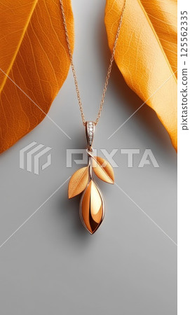 Delicate gold branch pendant with diamond accents against a light backdrop 125562335