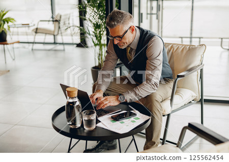 A Business Professional Engaging in Work within a Stylish Modern Office Environment Today A Business Professional Engaging in Work within a Stylish Modern Office Environment Today 125562454