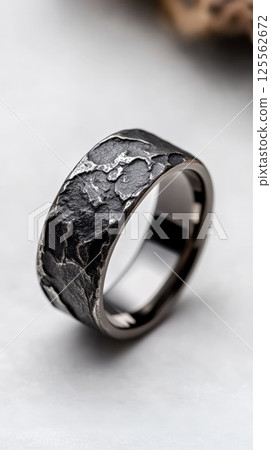 Bold oxidized silver ring with organic texture displayed against a minimalist backdrop 125562672