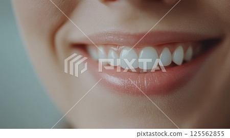 Close up of a smiling woman displaying perfect white teeth and soft pink lips, embodying ideals of beauty, health, and effective oral hygiene practices in cosmetology and dentistry 125562855