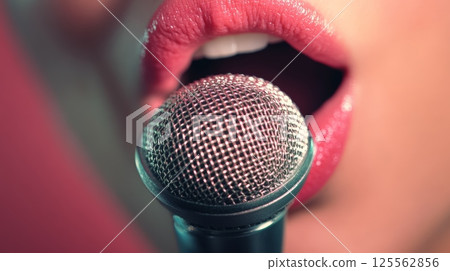 Close up of female singer with vibrant red lips passionately singing into a microphone, embodying the energy of live musical performances and the artistry of vocal expression 125562856