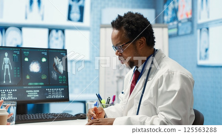 African american physician gives professional advice to woman patient, discussing about illness treatment and test results analysis. Doctor expert works in healthcare industry. Camera A. African american physician gives professional advice to woman patient, discussing about illness treatment and test results analysis. Doctor expert works in healthcare industry. Camera A. 125563288