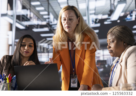 Female executives collaborating in a modern office analyzing data for business growth, women in business. CEOs discussing strategies for leadership development and achieving greatness together. 125563332