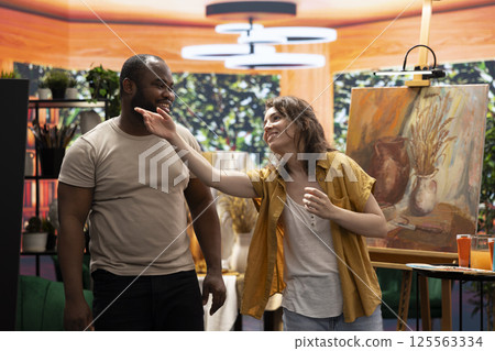 Painters team spend quality time on painting in their artistic studio, perfecting their latest masterpiece. Using multicolored pigments and innovative painting techniques to show their dedication. Painters team spend quality time on painting in their artistic studio, perfecting their latest masterpiece. Using multicolored pigments and innovative painting techniques to show their dedication. 125563334