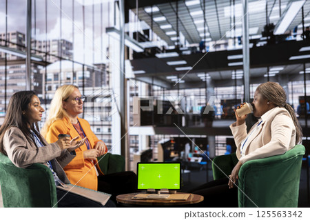 Diverse group of female colleagues ensuring goals achievement next to chroma key display, believing in equal rights and women empowerment. Powerful businesswomen work with resilience. Diverse group of female colleagues ensuring goals achievement next to chroma key display, believing in equal rights and women empowerment. Powerful businesswomen work with resilience. 125563342