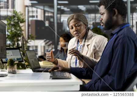 African american business team collaborates on global expansion strategy, using their extensive expertise to work on data driven decisions. Colleagues solving administrative tasks. African american business team collaborates on global expansion strategy, using their extensive expertise to work on data driven decisions. Colleagues solving administrative tasks. 125563388