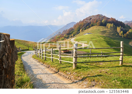 Picturesque Alps autumn landscape, wooden fence and mountain hills in Lombardy, Italy. Tourist adventure 125563446