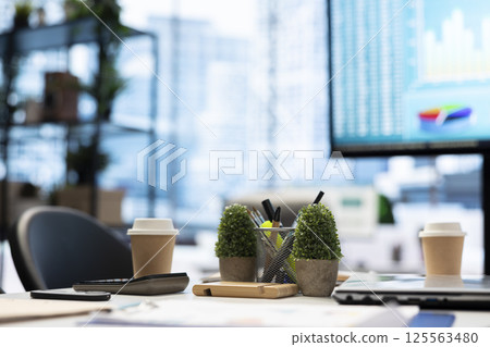 In a professional boardroom, computer screen showcases business data and statistics, aiding executives in strategy planning. Empty office space for meeting to help with workflow optimization. 125563480