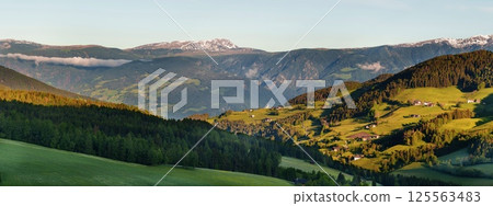 Scenic mountain landscape with green valleys and snow-capped peaks at sunrise near Valley of Funes at Dolomites, Italy Scenic mountain landscape with green valleys and snow-capped peaks at sunrise near Valley of Funes at Dolomites, Italy 125563483
