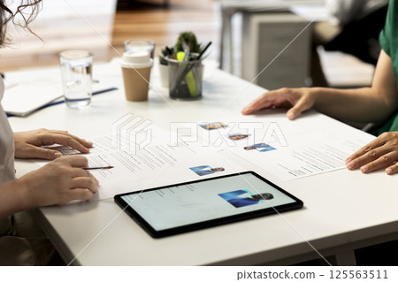 HR employee using tablet to determine if candidate possesses skills and experience needed to fulfil position role. HR manager using device to evaluate if applicant qualifications align with company 125563511
