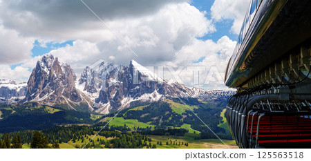Mountain train journey overlooking majestic peaks and lush valleys near Valley of Funes at Dolomites, Italy Mountain train journey overlooking majestic peaks and lush valleys near Valley of Funes at Dolomites, Italy 125563518