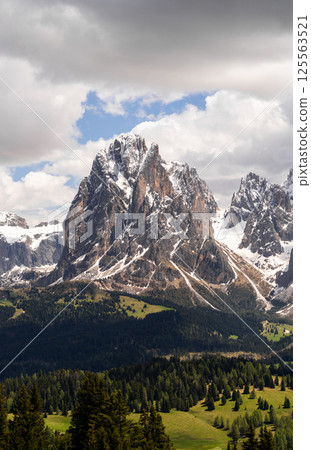Majestic mountain peak in alpine landscape with snow and pine forest scenery near Valley of Funes at Dolomites, Italy 125563521