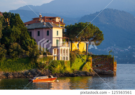 Colorful Lakeside Villas with Boat at Sunset at Varenna, lake Como, Italy 125563561