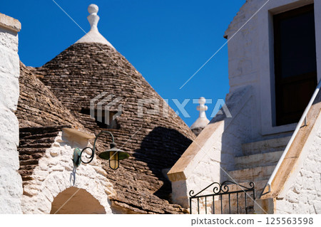 Trulli rooftops and white stone building in Alberobello 125563598