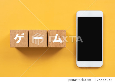 A block with the word "game" written on it and a smartphone 125563938