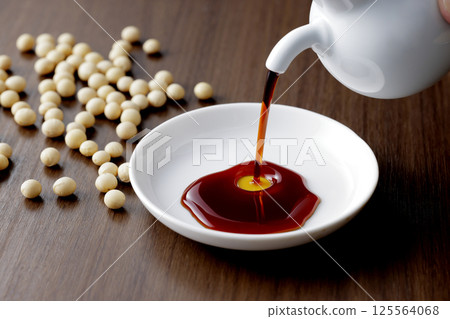 Pour soy sauce into a small plate Pour soy sauce into a small plate 125564068