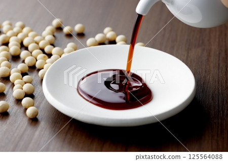 把醬油倒在一個小盤子裡 把醬油倒在一個小盤子裡 125564088