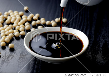 Pour soy sauce into a small plate 125564102