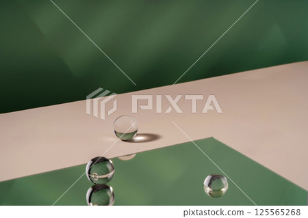 Cosmetic background podium for product presentation. Showcase mock up for perfume advertising, cosmetics stand, branding scene with ball. Green backdrop with transparent sphere decor, display 125565268