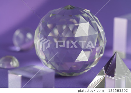 Crystal prism refracting light, magic crystals and pyramid, sphere and cube on purple background. Spiritual healing crystal practice. Feng Shui, good energy flow concept background.. Crystal prism refracting light, magic crystals and pyramid, sphere and cube on purple background. Spiritual healing crystal practice. Feng Shui, good energy flow concept background.. 125565292