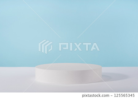 Podium pedestal for cosmetic product packaging on blue background. Showcase for jewellery presentation, white platform for perfume advertising, cosmetics stand background, branding scene Podium pedestal for cosmetic product packaging on blue background. Showcase for jewellery presentation, white platform for perfume advertising, cosmetics stand background, branding scene 125565345