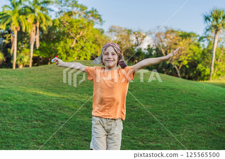 Boy wearing a pilot hat running through the grass with a toy airplane, dreaming of adventures. Childhood, imagination, and freedom concept Boy wearing a pilot hat running through the grass with a toy airplane, dreaming of adventures. Childhood, imagination, and freedom concept 125565500